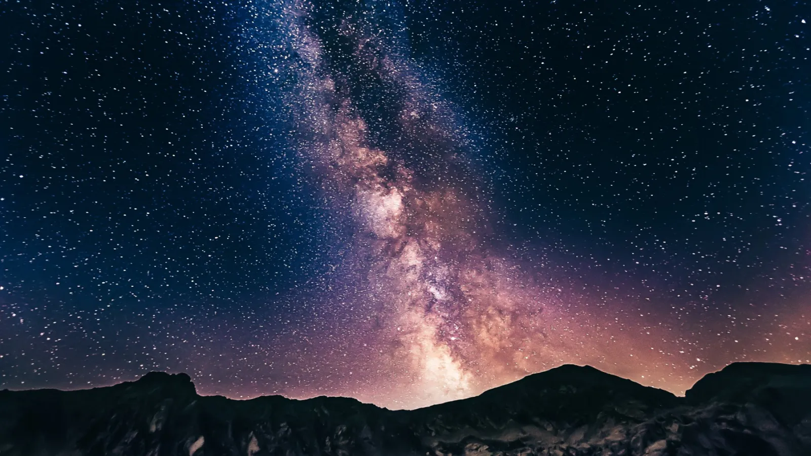Image of the Milky Way stretching above a mountain range.