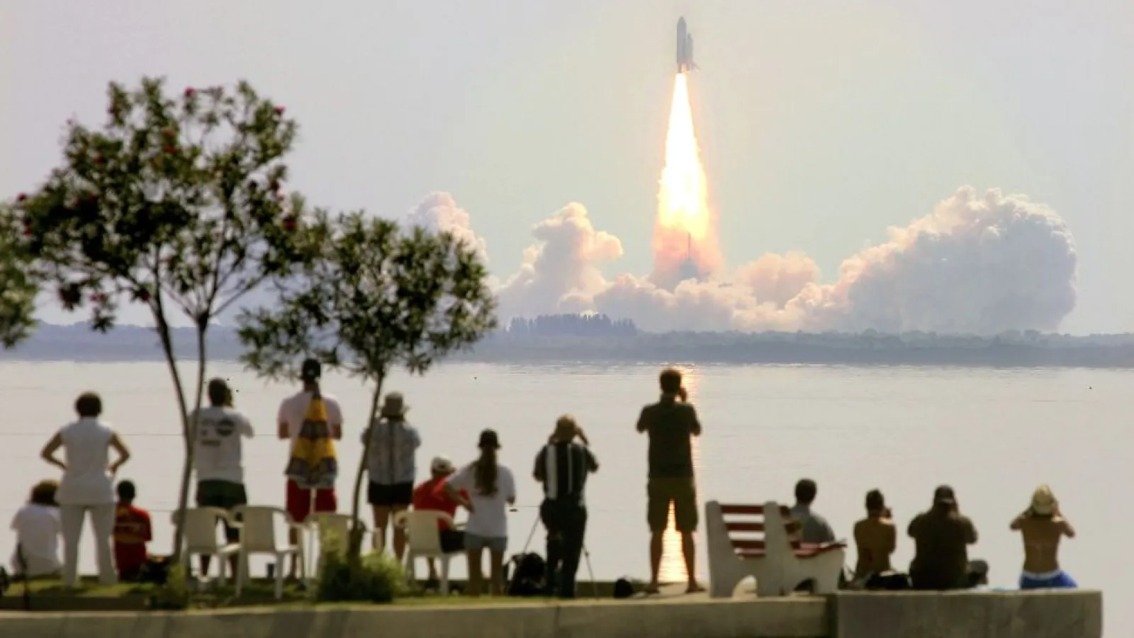 Space Shuttle Discovery lifts off from Kennedy Space Center as onlookers watch July 26, 2005, in Titusville, Florida. The shuttle crewmembers would have experienced time dilation and perceived the trip as taking less time than those on the ground. (Image credit: Mario Tama/Getty Images)
