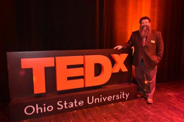 Dr. Michael Stamatikos Next to TEDx Sign